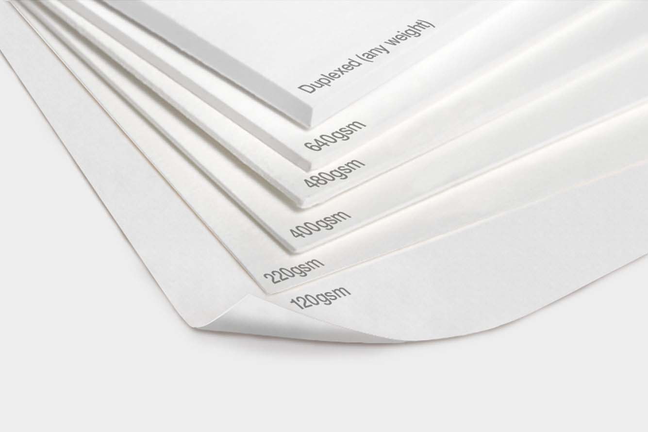 sheets of paper of different thicknesses placed one on top of another to show how GSM or grams per square meter is a measure of paper thickness